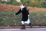 Amish woman rollerblading by Dennis L. Hughes