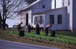 Amish family in garden by Dennis L. Hughes