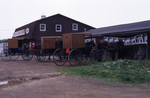 Brown top buggies outside hardware store by Dennis L. Hughes