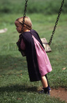 Amish girl on swing by Dennis L. Hughes