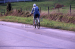 Amish woman bicycling by Dennis L. Hughes