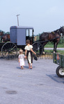 Two Amish girls at produce auction by Dennis L. Hughes