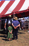 Two Amish men and young girl at mud sale by Dennis L. Hughes