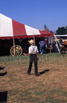 Amish boy standing in front of tent by Dennis L. Hughes