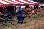 Amish woman examines buggies at mud sale by Dennis L. Hughes