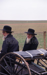 Amish men lean on buggy by Dennis L. Hughes