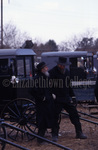 Two Amish men talk next to buggies by Dennis L. Hughes