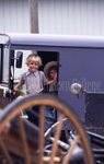 Amish boys looking out of buggy by Dennis L. Hughes
