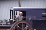 Amish boy in door of buggy by Dennis L. Hughes