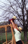 Amish man assists Amish boy on playground by Dennis L. Hughes