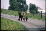 Amish boys walk with scooter by Dennis L. Hughes