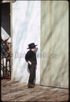 Amish boy leaning against wall by Dennis L. Hughes