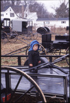 Amish child stands on trailer by Dennis L. Hughes