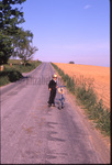 Boy stands with bicycle by Dennis L. Hughes