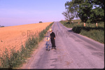 Amish boy with scooter by Dennis L. Hughes