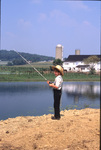 Amish boy fishing by Dennis L. Hughes