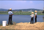 Three boys fish in lake by Dennis L. Hughes